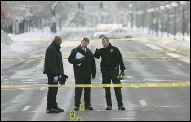 Crime scene tape and evidence markers on a winter roadway